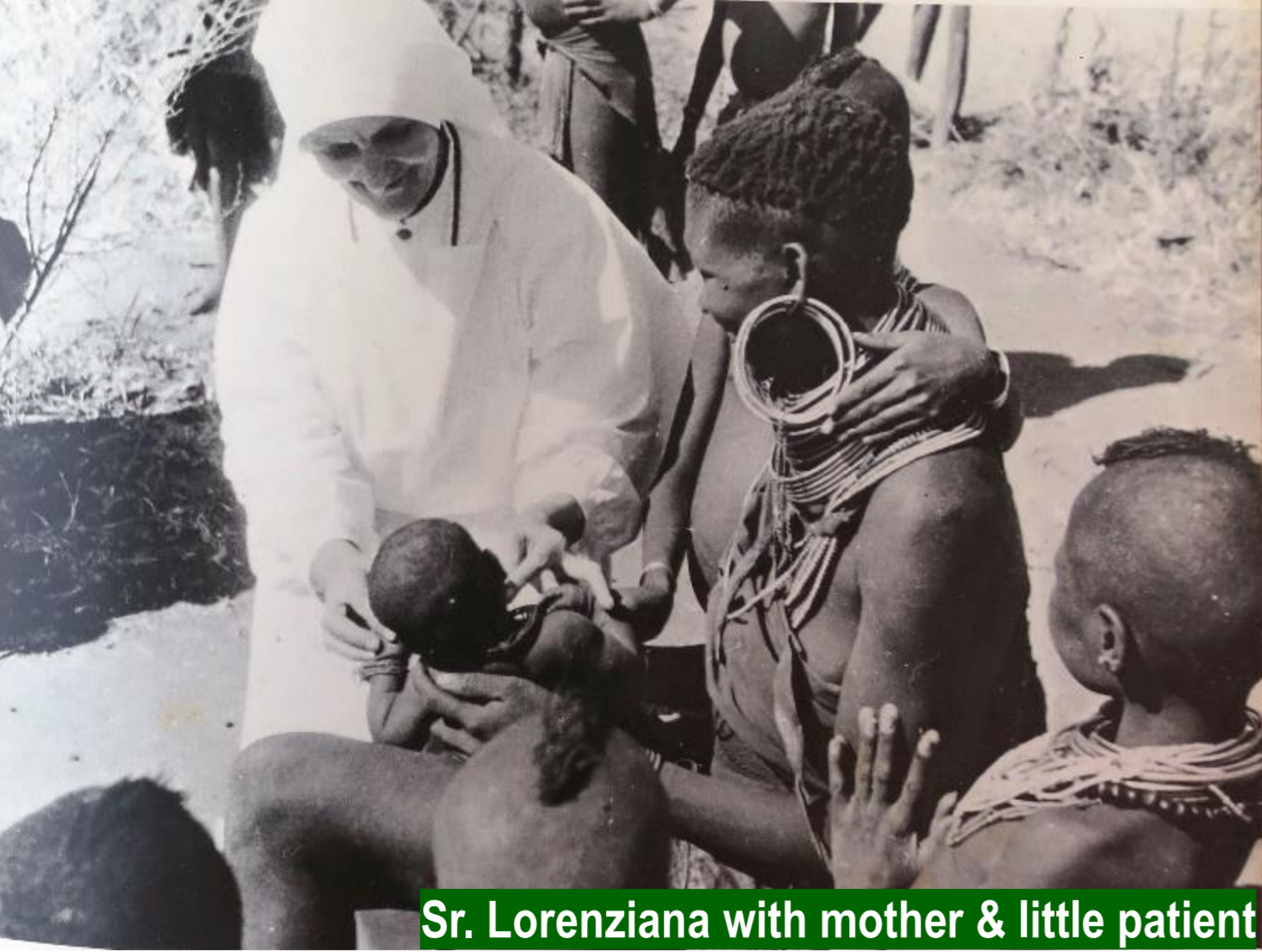 a black and white photo of sister lorenziana comforting a mother holding a newborn