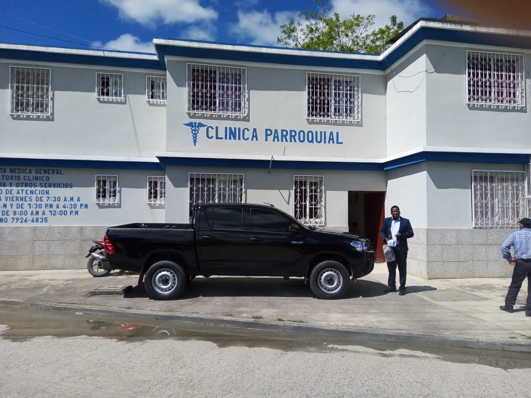 a new black truck is parked in front of a medical facility with the words "clinic parroquial" on the front