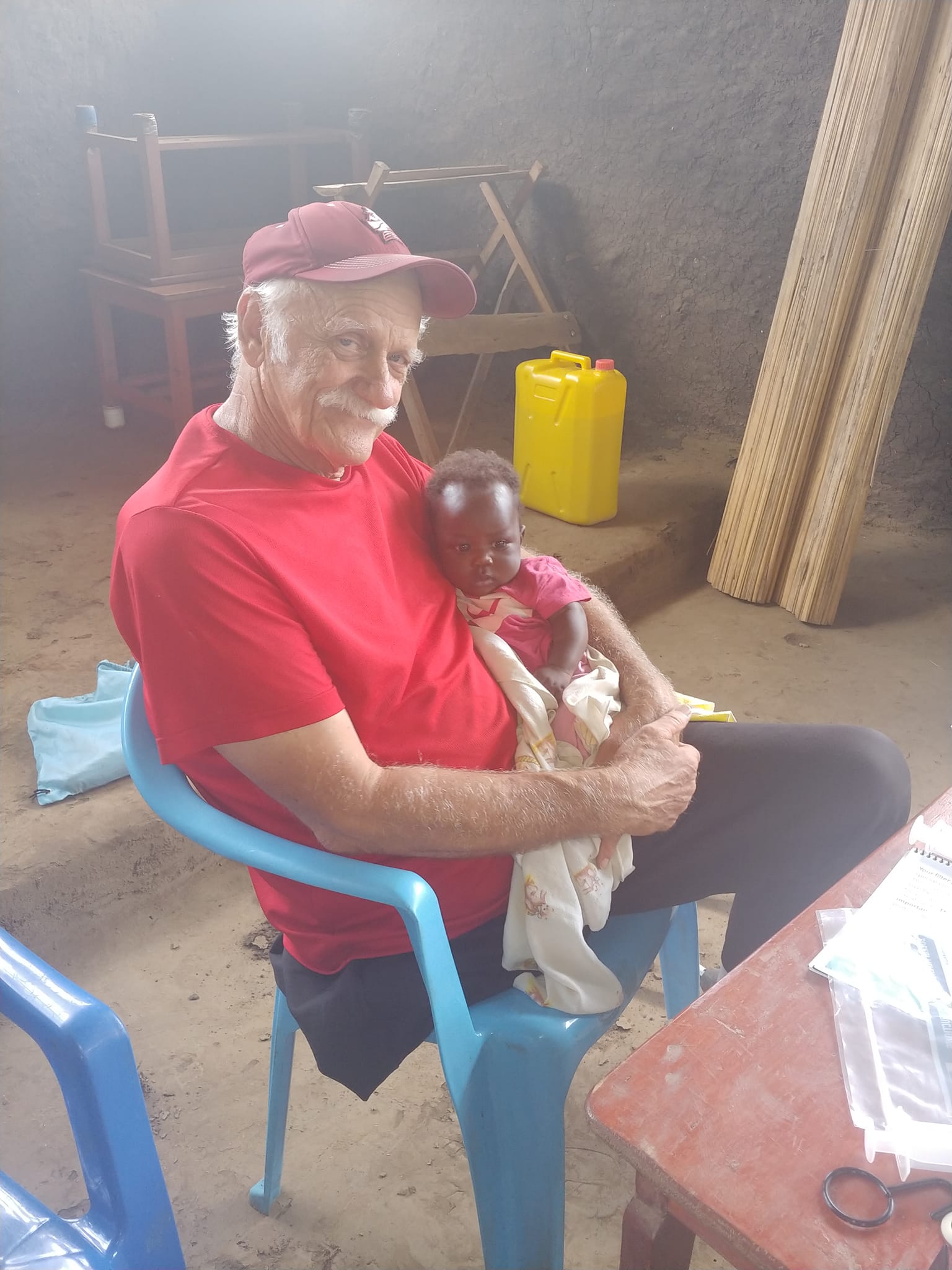 Jim Wilhite holds a baby while a mother learns how to use and care for her new water filter.