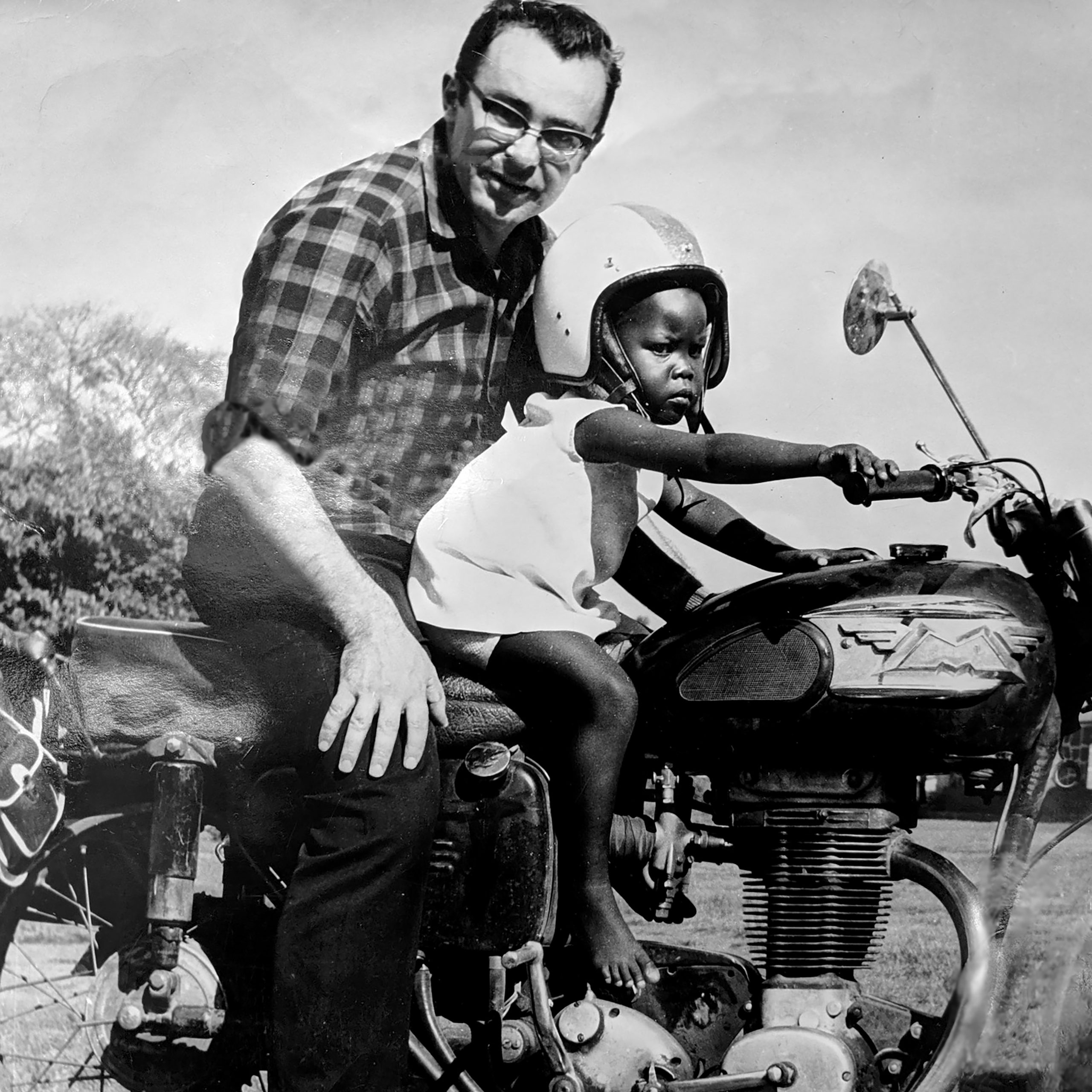 Fr Louie on a motorcycle in Uganda with a helper