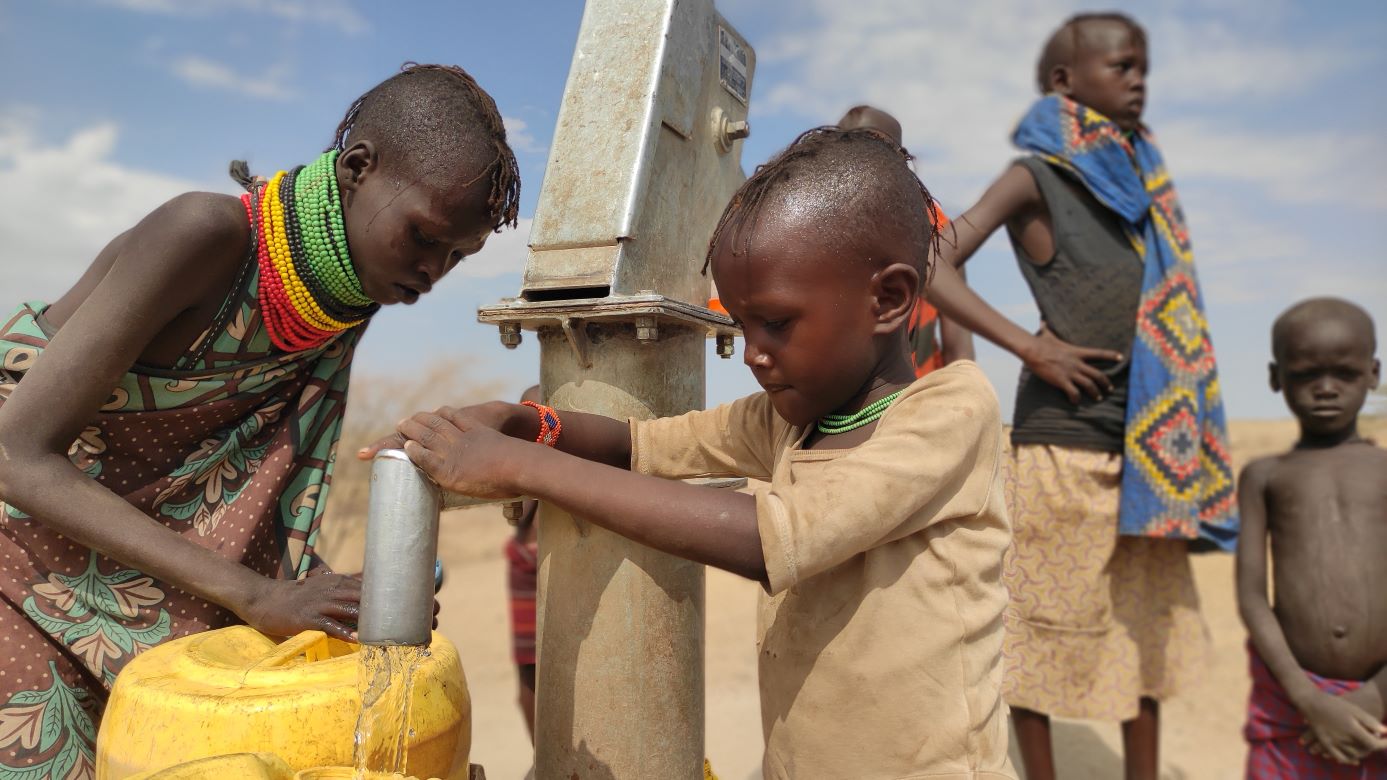 Massai children in Kenya fill jerry cans with clean water from a bore hole