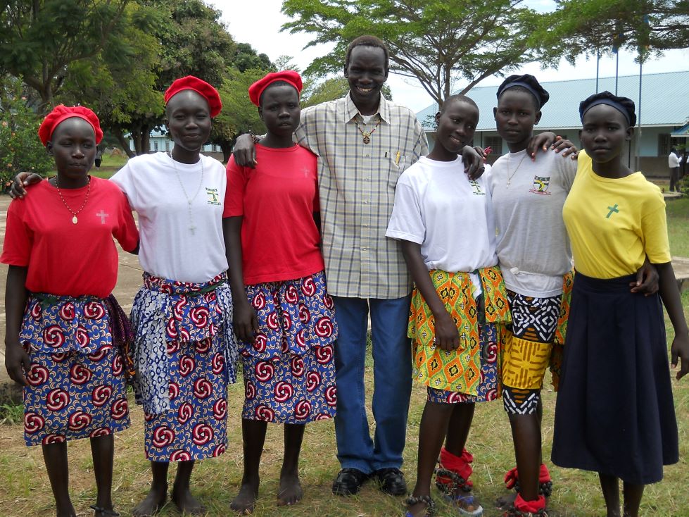 Fr Louis stands shoulder to shoulder with female graduates of a South Sudan school