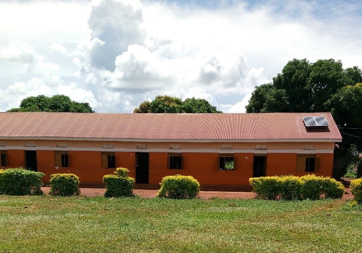 Solar panels are on the roof of a one story school building