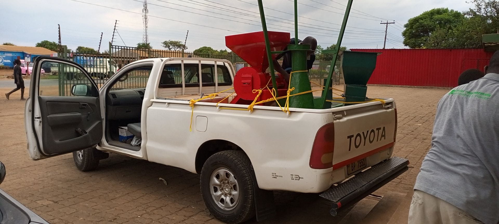 An oil presser and miller is delivered in the back of a white pickup truck