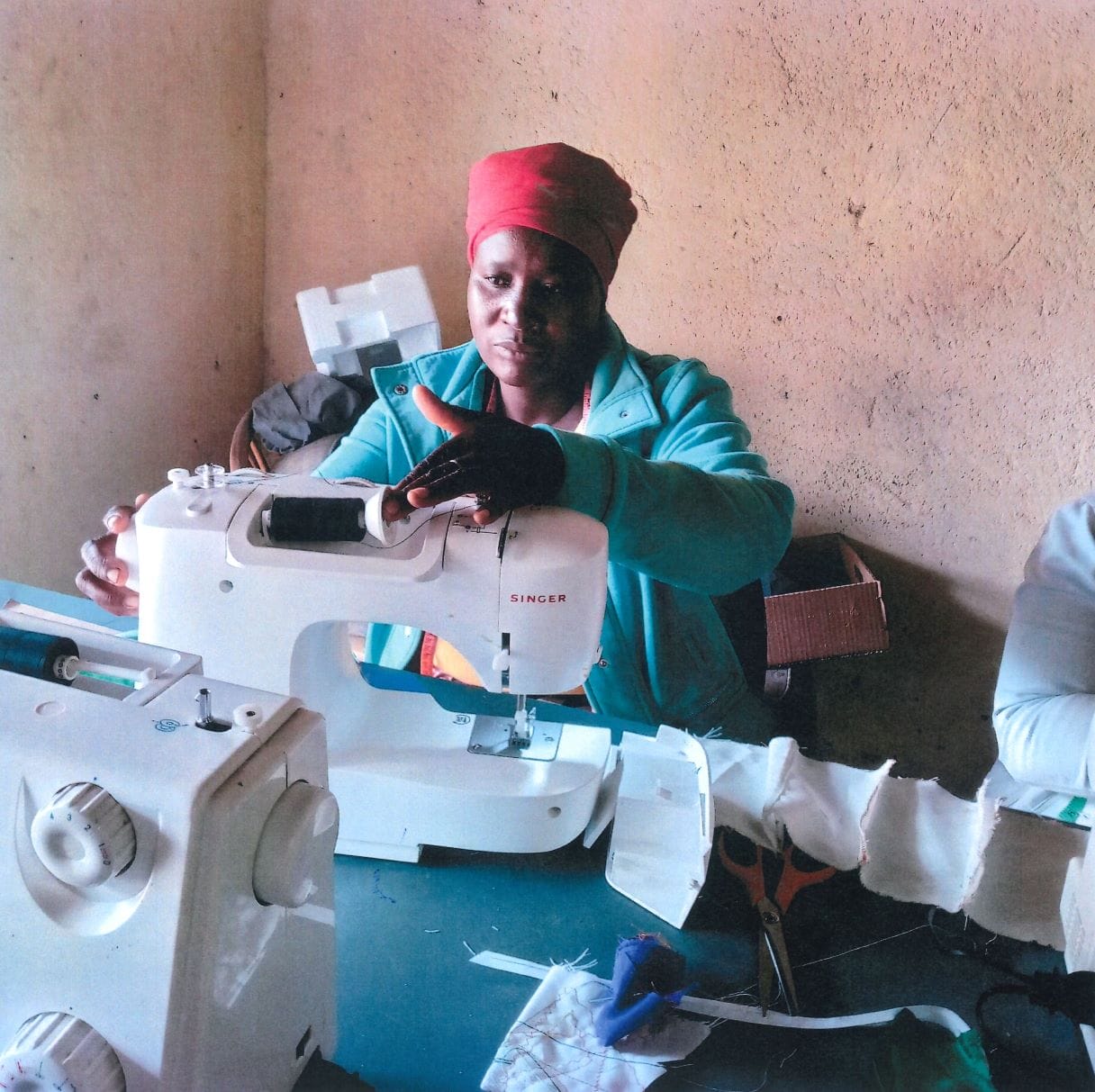 Student working on a sewing machine A young, South African mother practices sewing items on a sewing machine.