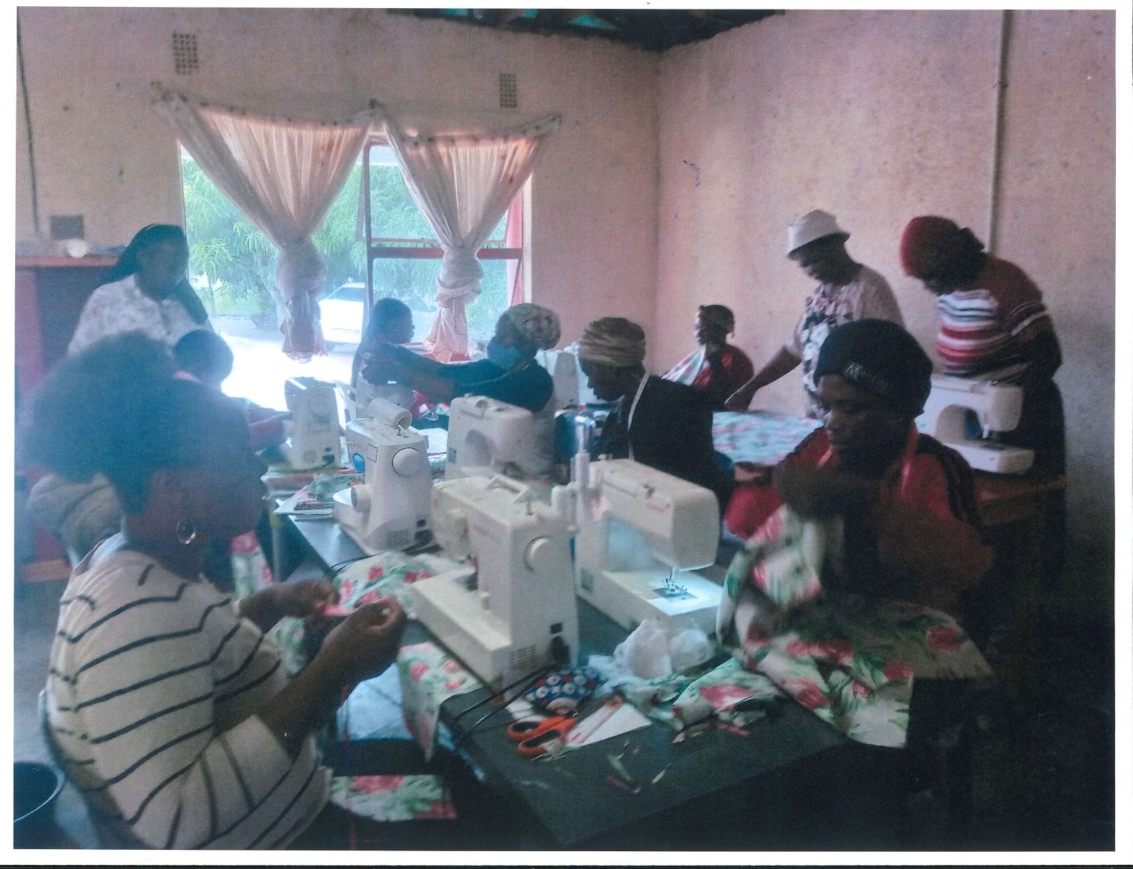 Nine South African women sit at sewing machines working on new projects