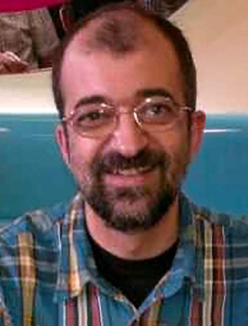 Fr Ismael, wearing glasses and a plaid shirt