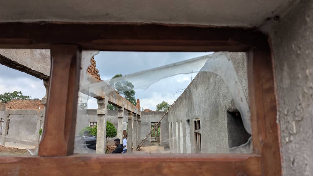 A shattered window and decimated buildings show the damage of war in Congo