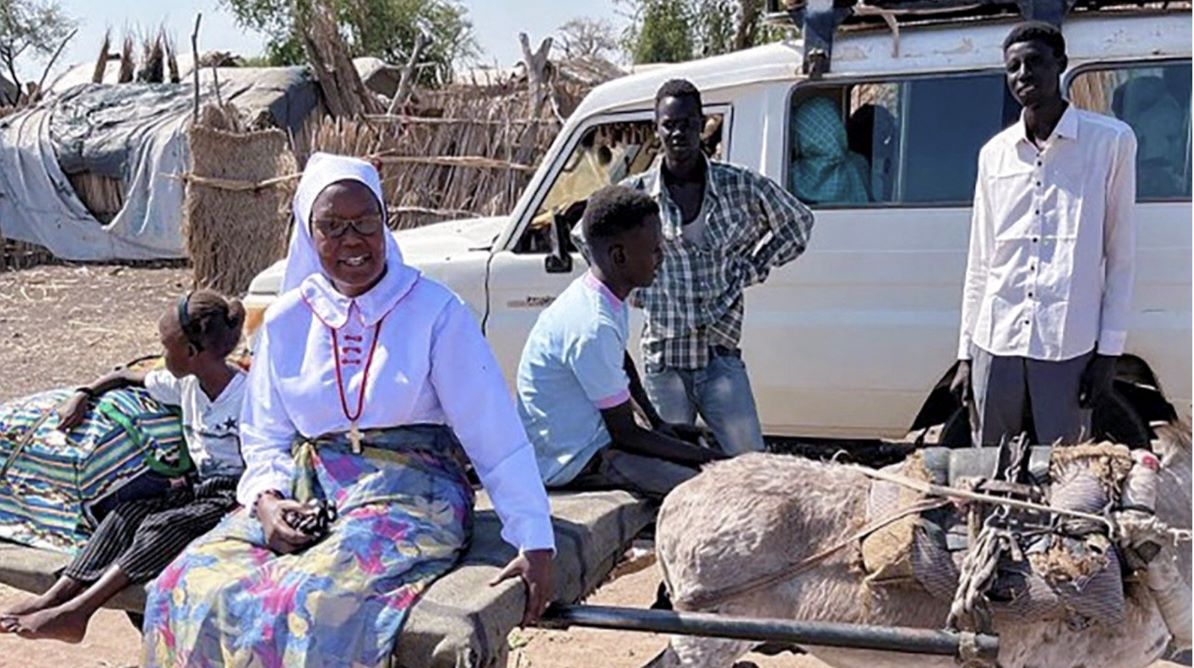 Sister Georgina sits on the side of the road resting, her donkey next to her